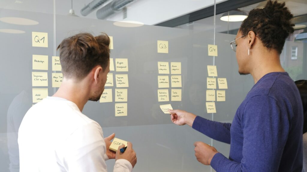 Two product planners reviewing a quarterly software roadmap on sticky notes