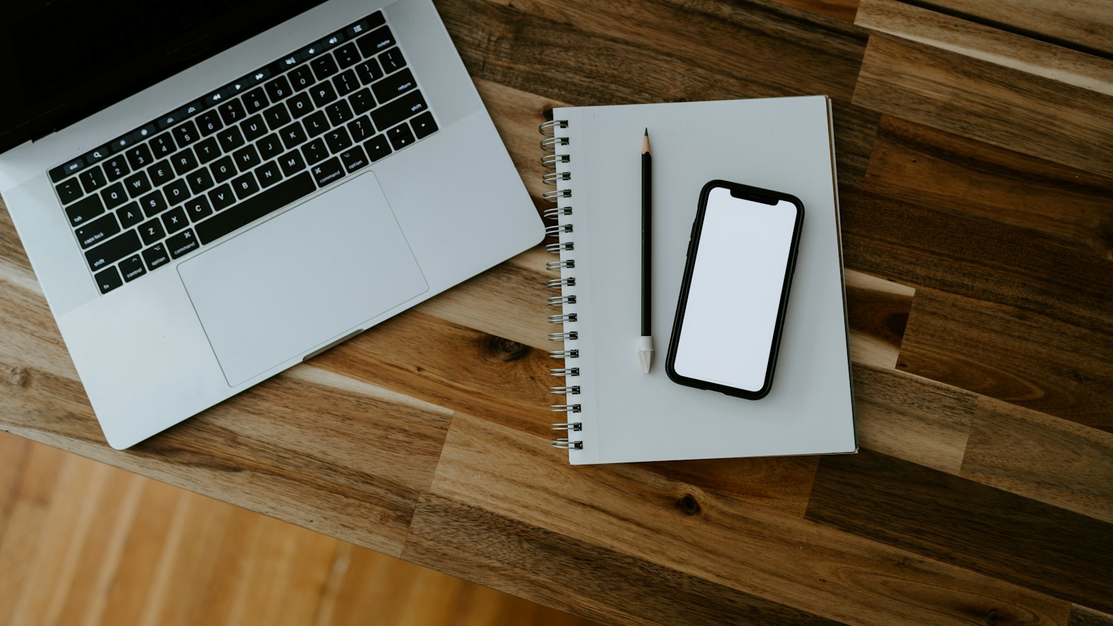 Laptop and smartphone side by side on a desk during multi-device product planning